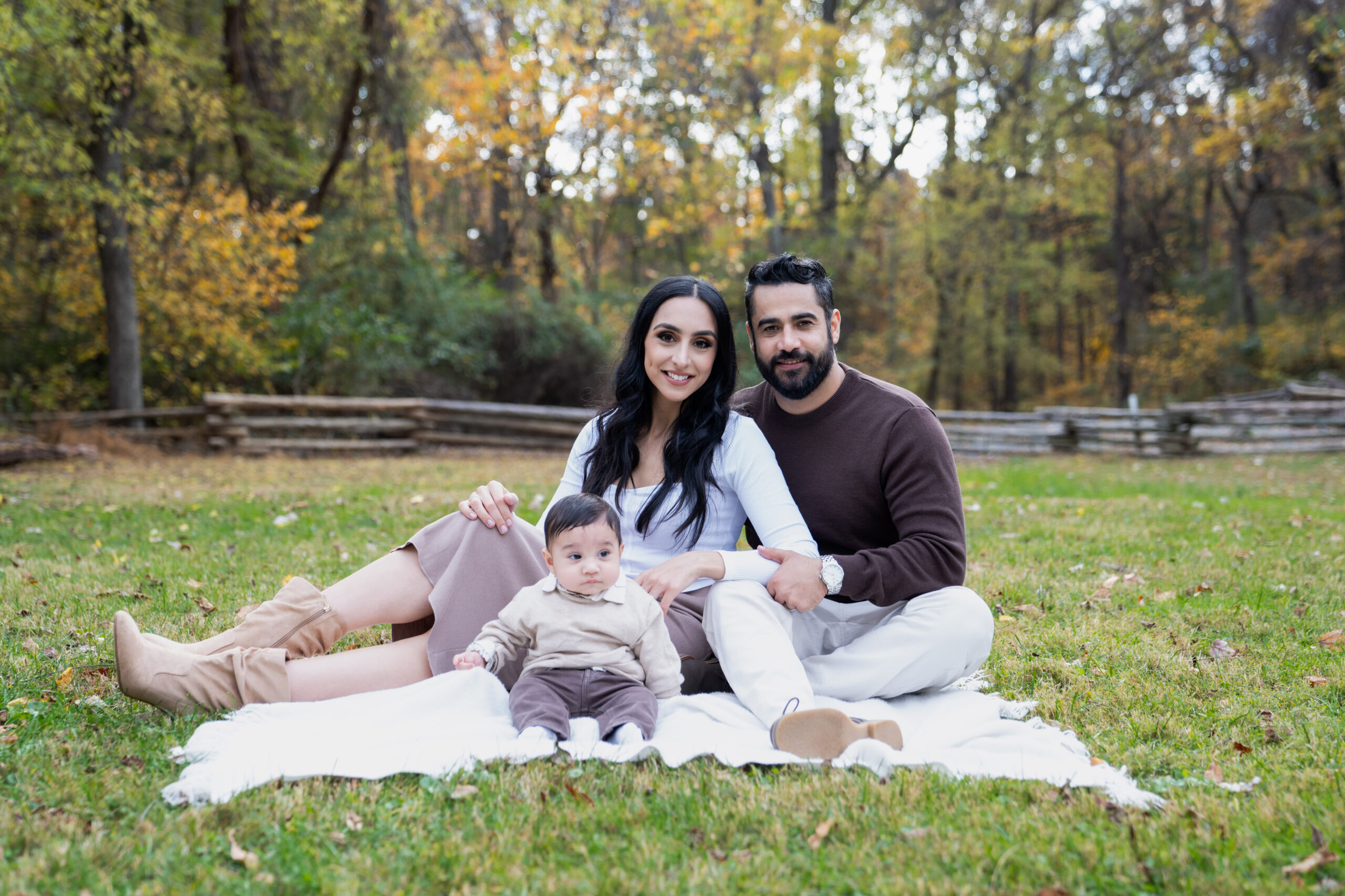 Couple sitting with their baby, sitting and smiling